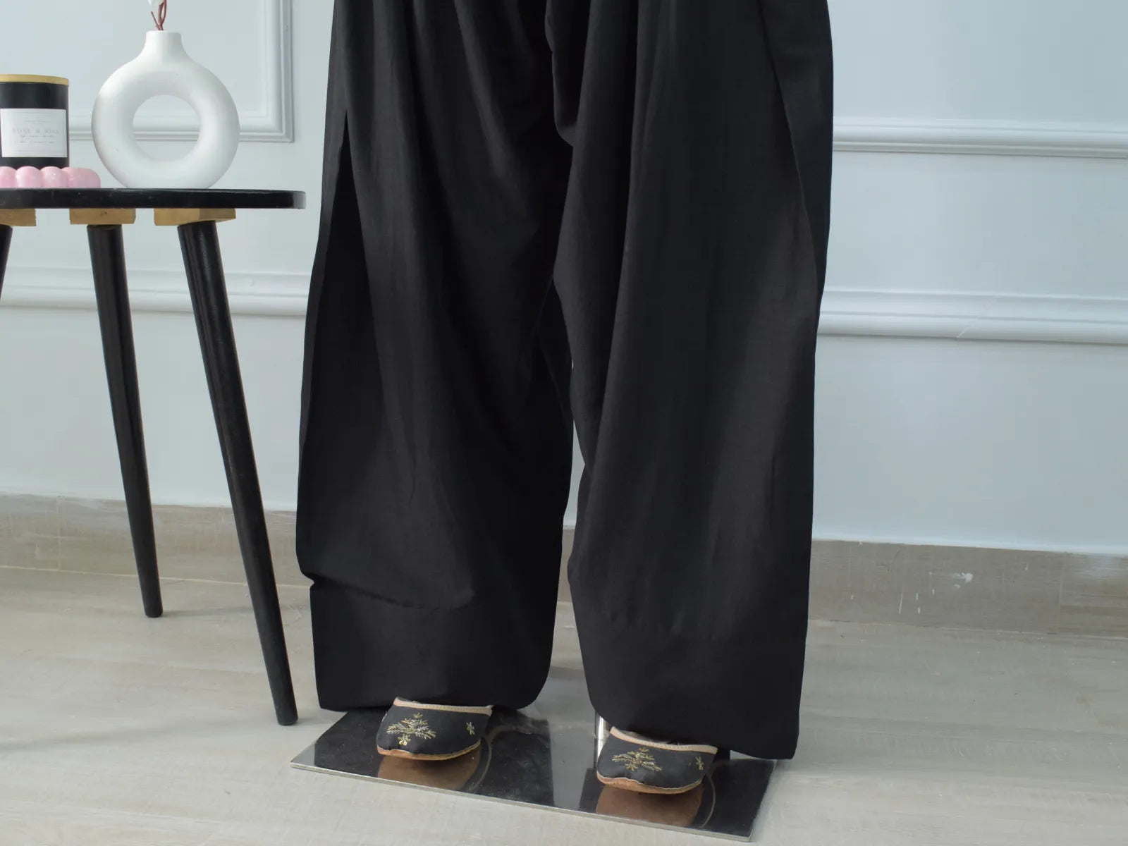 Black Farshi Shalwar front view on mannequin – elasticated waist, traditional gathers, wide flowing silhouette paired with black floral kurti