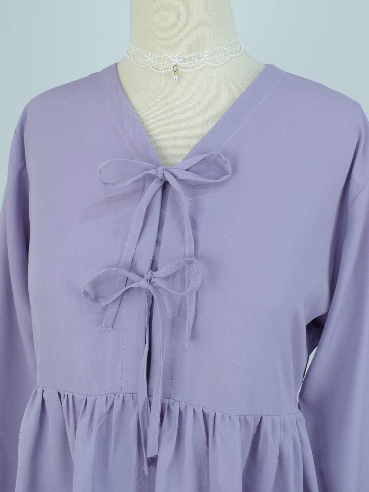 Front detail shot of lilac bow tie top highlighting V-neckline and double ribbon closures on mannequin