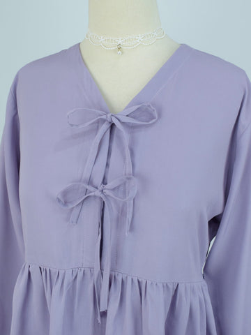 Front detail shot of lilac bow tie top highlighting V-neckline and double ribbon closures on mannequin