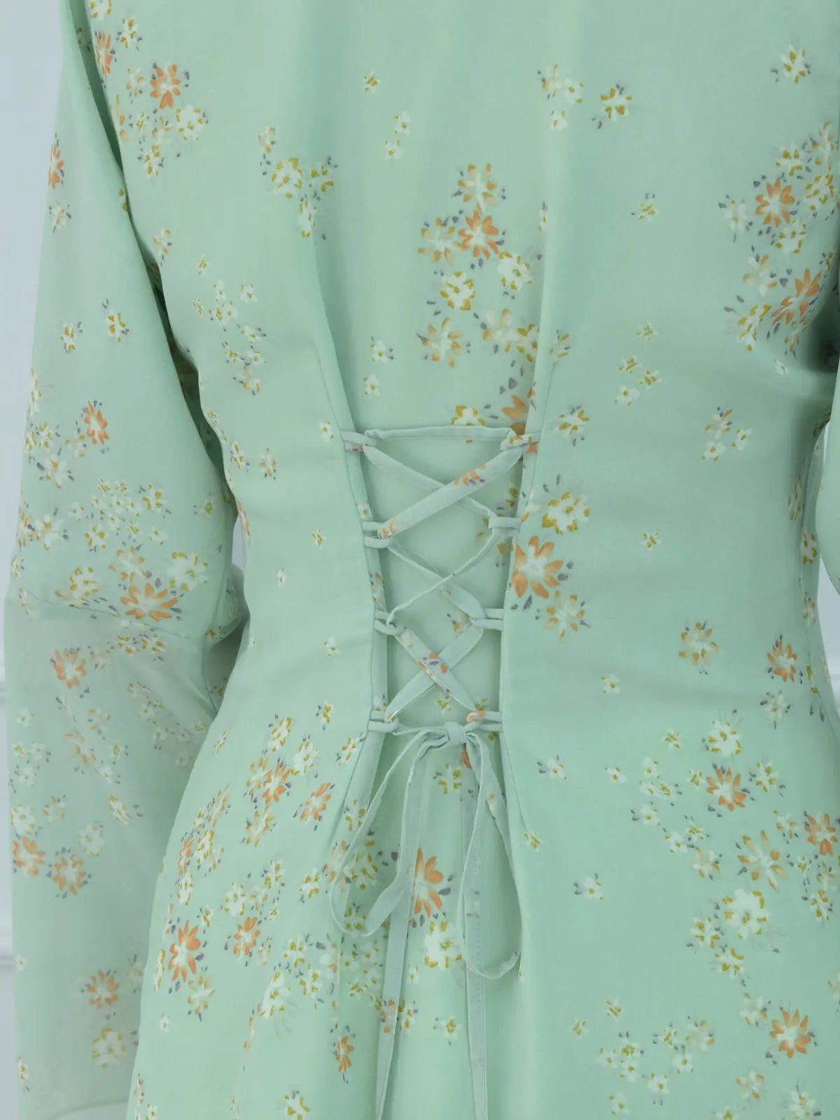 Close-up of corset lace-up back on green floral kurti