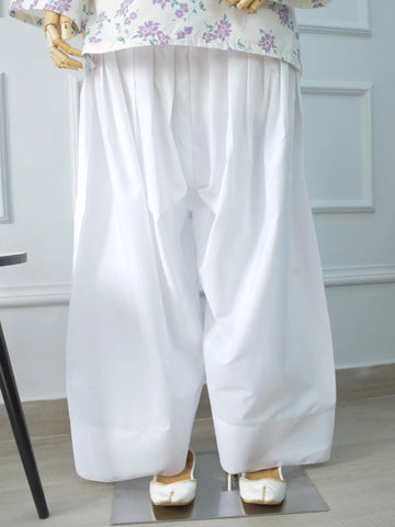 White Farshi Shalwar broad hem close-up on mannequin – wide leg finish with white khussa footwear, soft cotton fabric