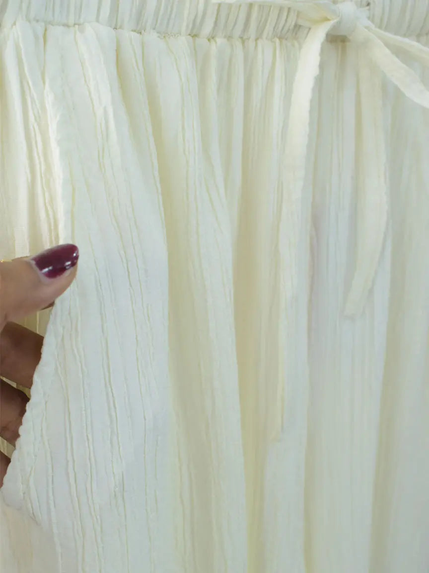 Close-up of DOVE textured off-white wide-leg pants fabric