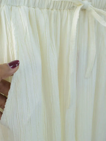 Close-up of DOVE textured off-white wide-leg pants fabric