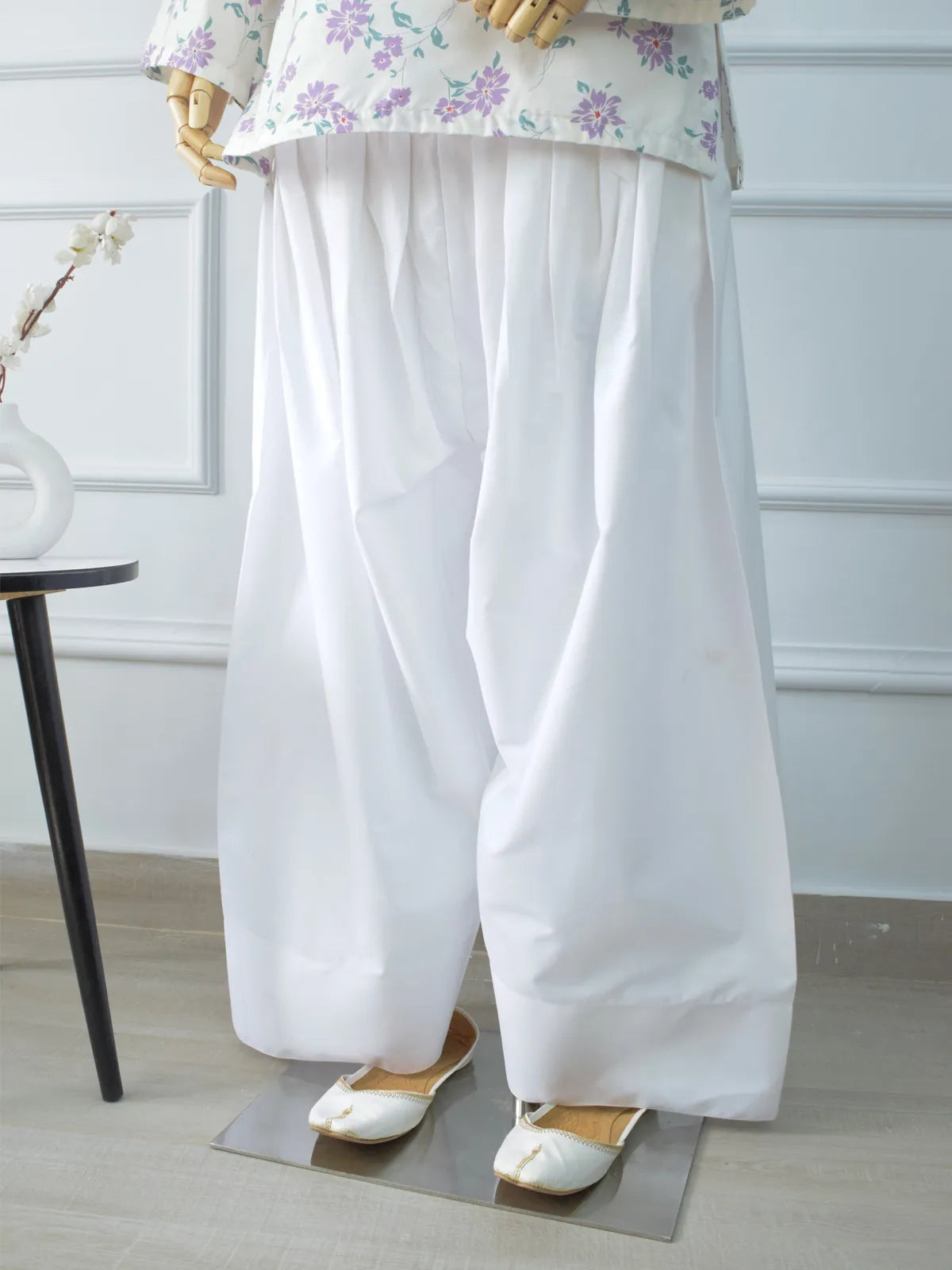 White Farshi Shalwar front view on mannequin – elasticated waist, traditional gathers, wide flowing legs, paired with floral kurti