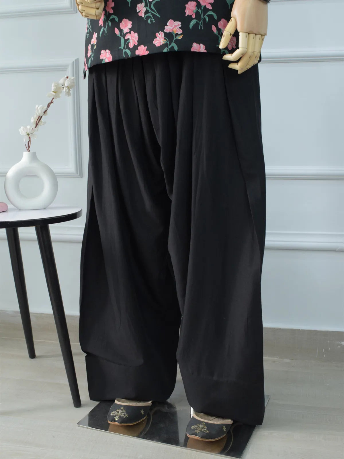 Black Farshi Shalwar broad hem close-up on mannequin – wide leg finish with black embroidered khussa footwear, soft cotton fabric