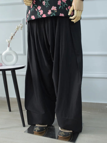 Black Farshi Shalwar broad hem close-up on mannequin – wide leg finish with black embroidered khussa footwear, soft cotton fabric