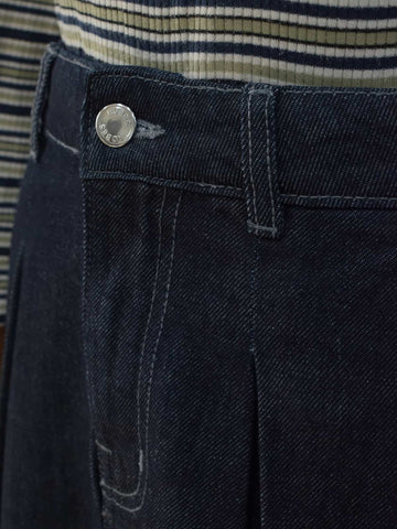 Close-up of denim skirt waistband showing silver button closure and side pocket detail