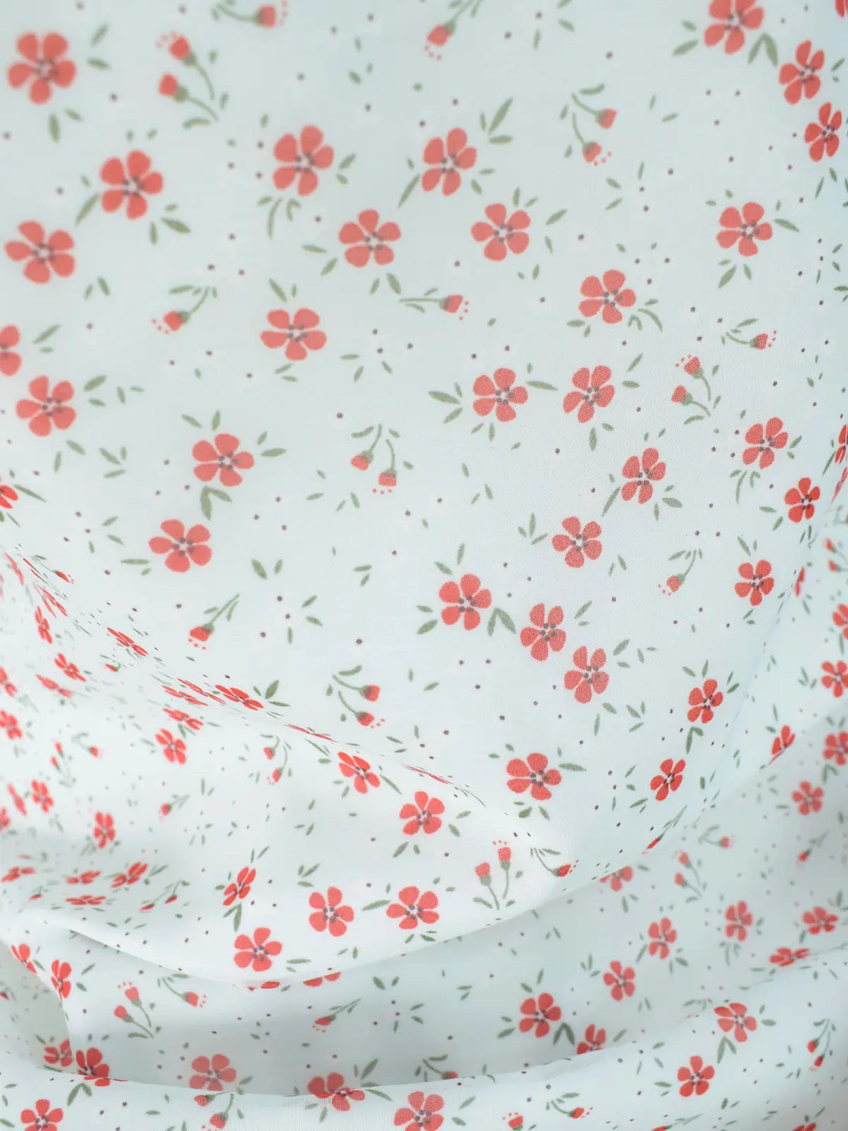 Close-up of white chiffon fabric, red floral print