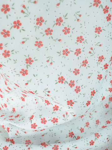Close-up of white chiffon fabric, red floral print