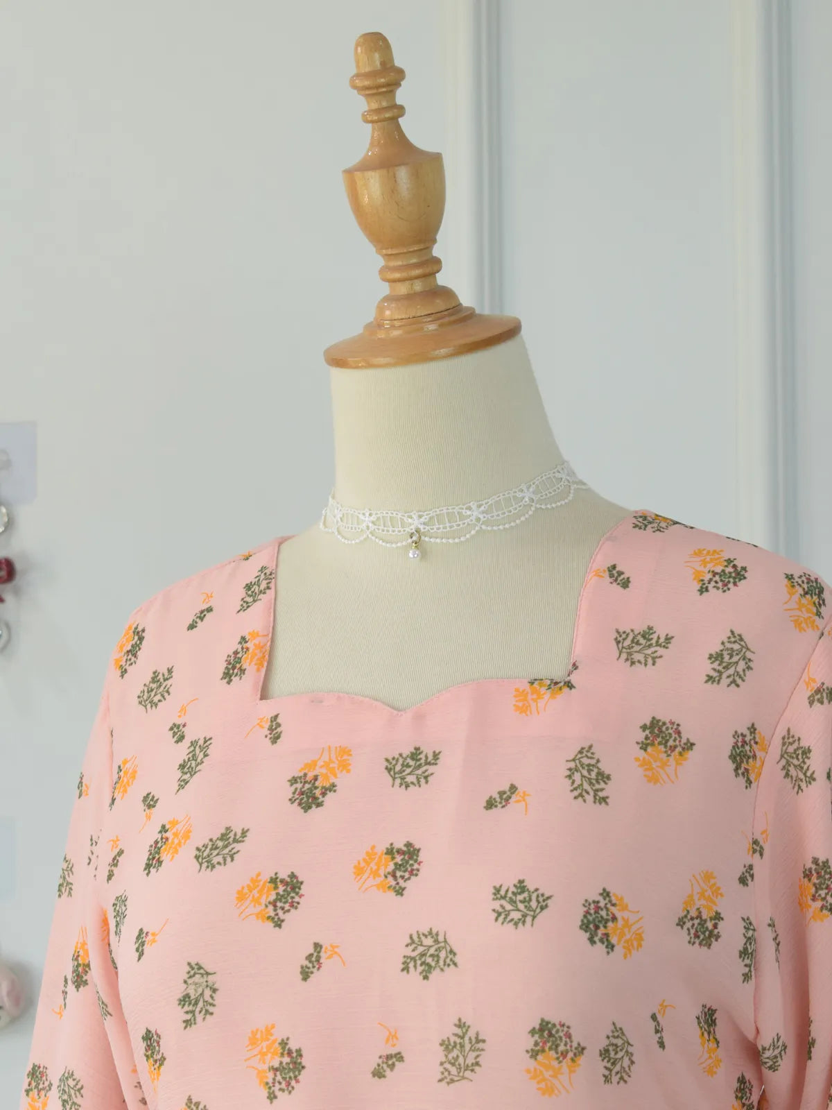 Close-up of sweet heart neckline on ROBES Azelia light pink floral chiffon kurti on mannequin