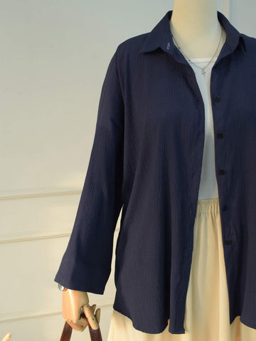 Detail shot of buttons and collar on navy blue textured shirt