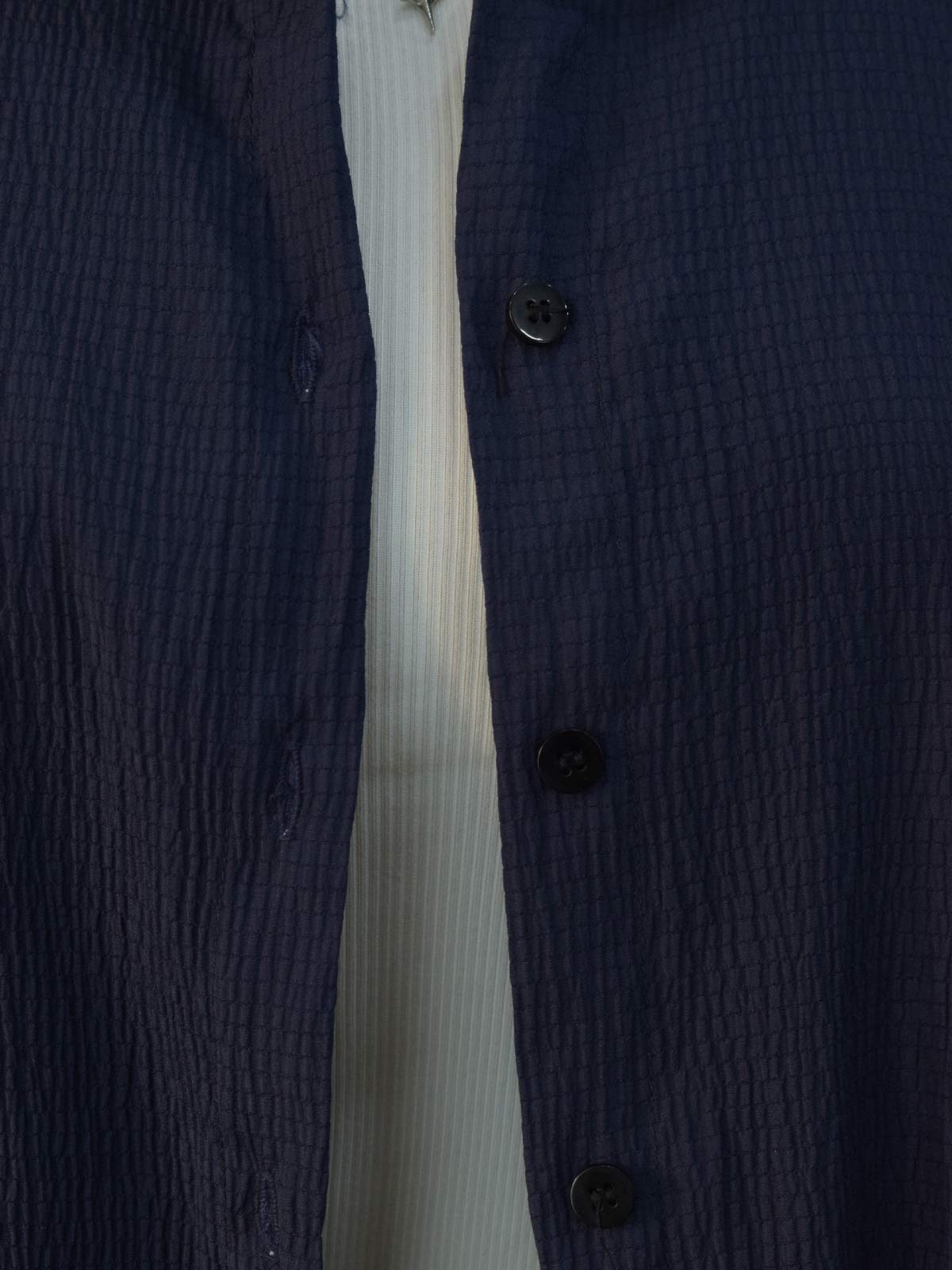 Detail shot of buttons on navy blue textured shirt