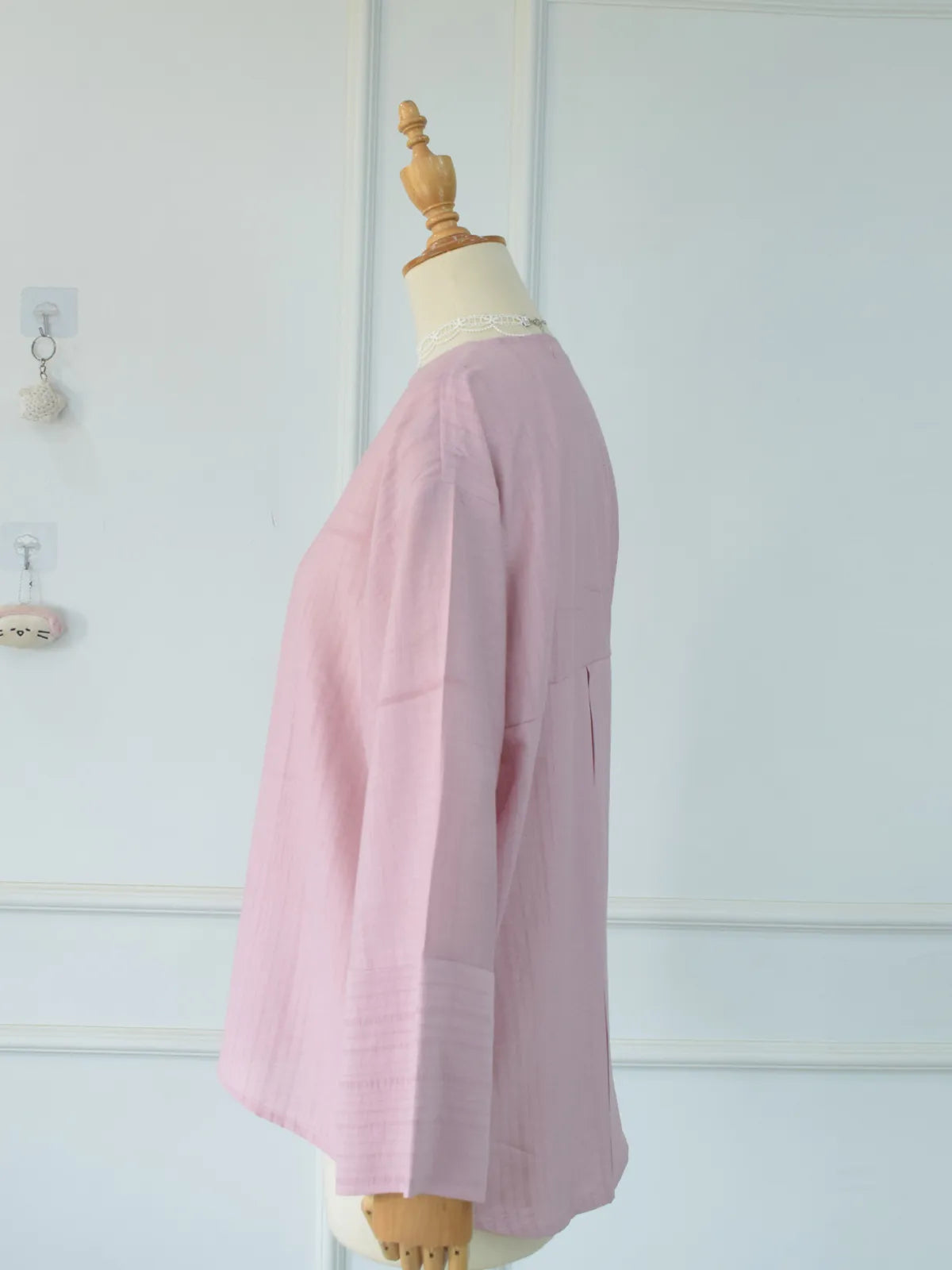 Side profile view of blush pink oversized button-down top on mannequin showing length and silhouette